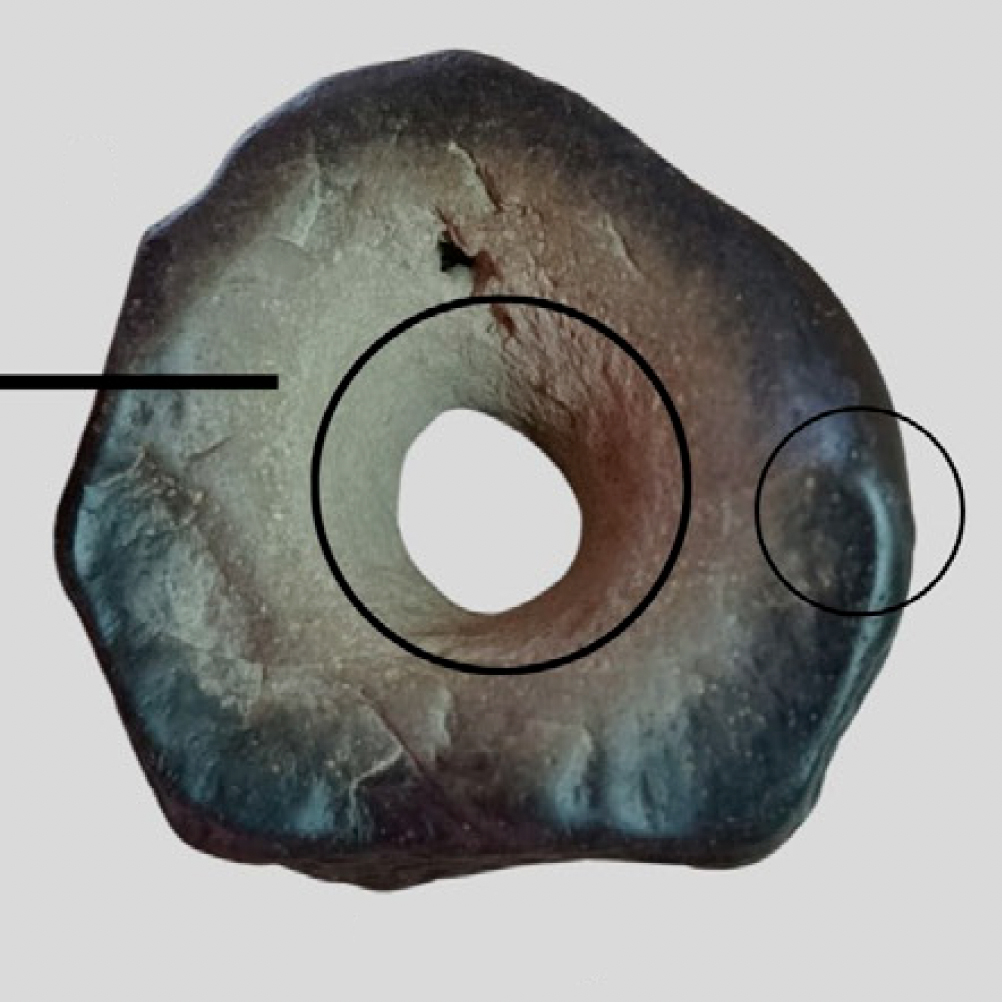 Cara A no expuesta, vista macroscópica total, donde se observa perforación y pronunciado desgaste de las aristas en todo el perímetro de la pieza